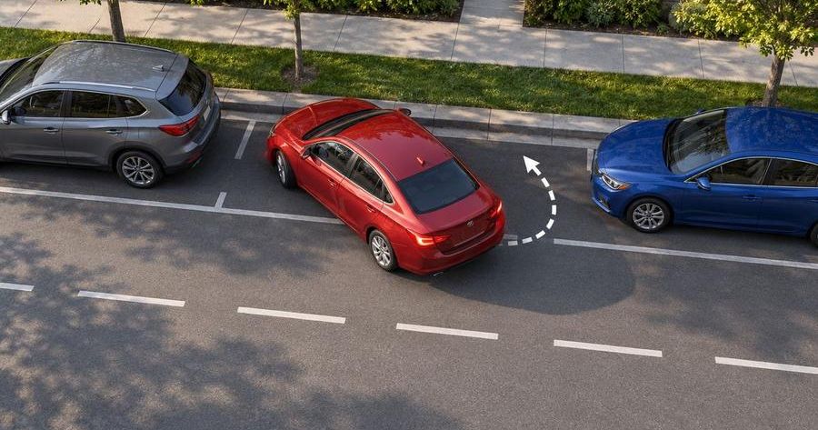 Overhead view of a driver parallel parking between two parked cars, one of the skills the examiner checks. Practice before your Wayne road test.
